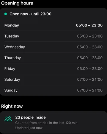 The gym page in the member app: opening hours, and 23 people inside right now.
